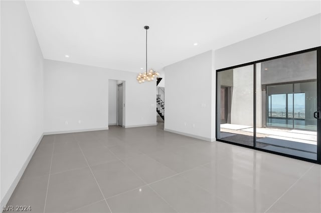 tiled empty room with a chandelier