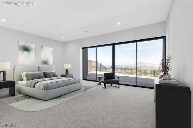 bedroom featuring light carpet, a mountain view, and access to exterior