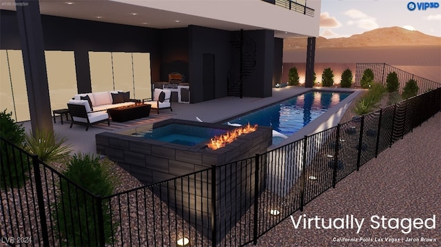 pool at dusk with an outdoor living space, a patio area, a mountain view, and an in ground hot tub