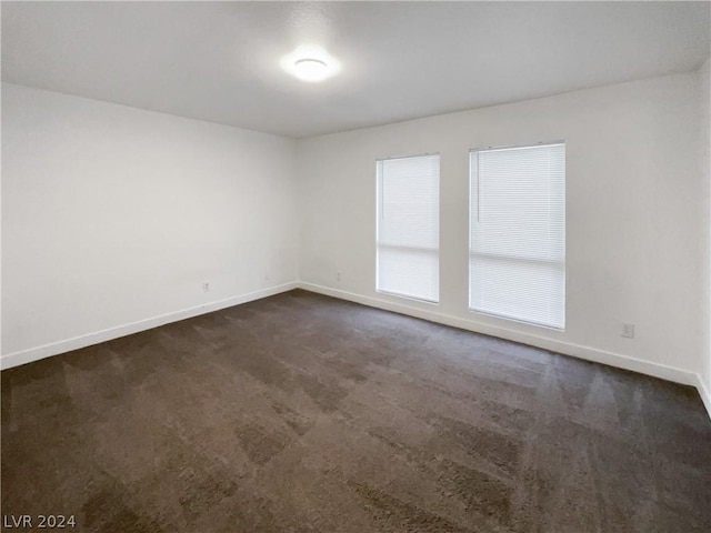 empty room with dark colored carpet