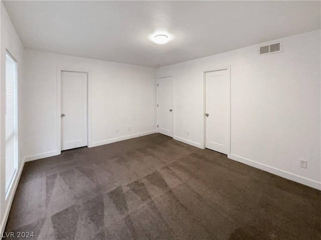 empty room with dark carpet