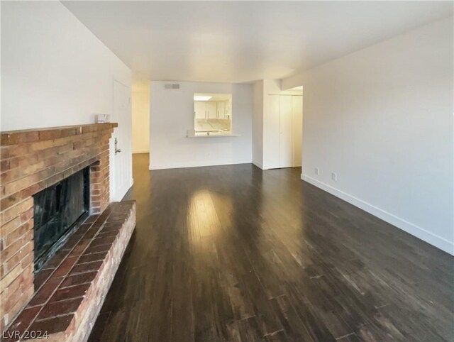 unfurnished living room featuring dark hardwood / wood-style flooring and a fireplace