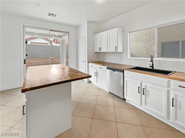 kitchen featuring white cabinets, a kitchen island, stainless steel dishwasher, sink, and butcher block countertops