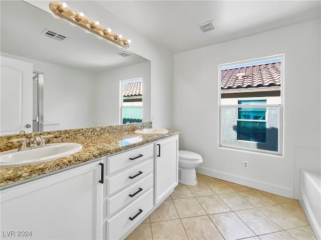 bathroom featuring vanity, toilet, a bathtub, and tile patterned flooring