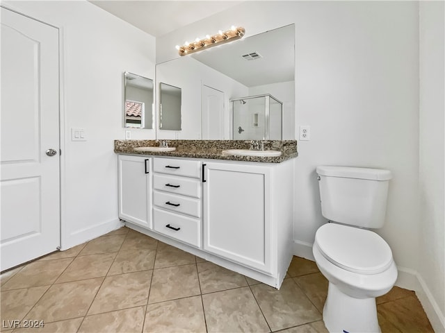 bathroom with vanity, walk in shower, toilet, and tile patterned floors