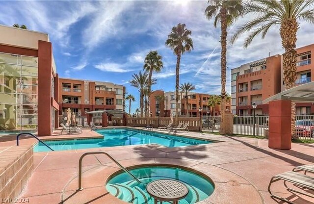 view of swimming pool featuring a hot tub and a patio area