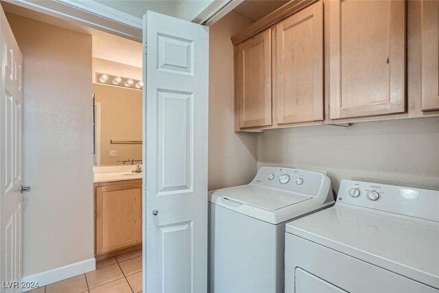 washroom with cabinets, washer and dryer, and light tile patterned floors