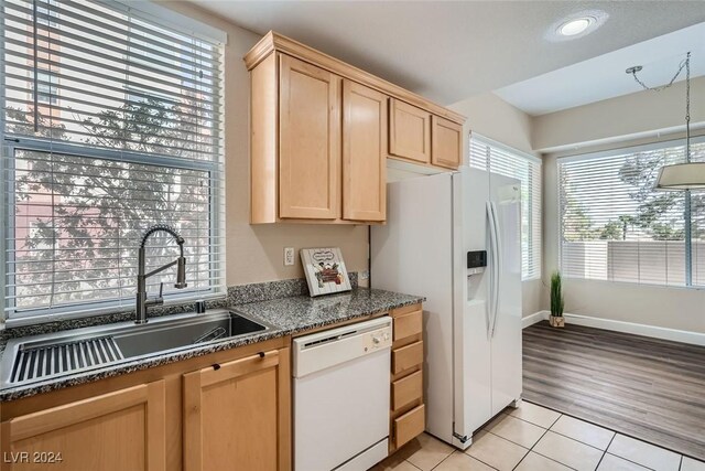 kitchen with light tile patterned flooring, sink, light brown cabinetry, and white appliances