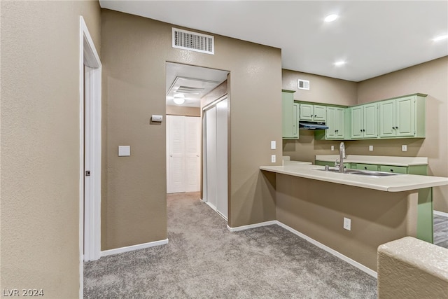 kitchen with light carpet, a kitchen breakfast bar, kitchen peninsula, and green cabinets