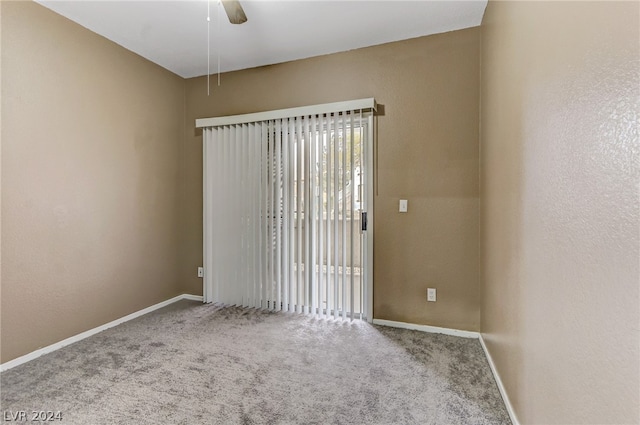 carpeted empty room with a ceiling fan, a textured wall, and baseboards