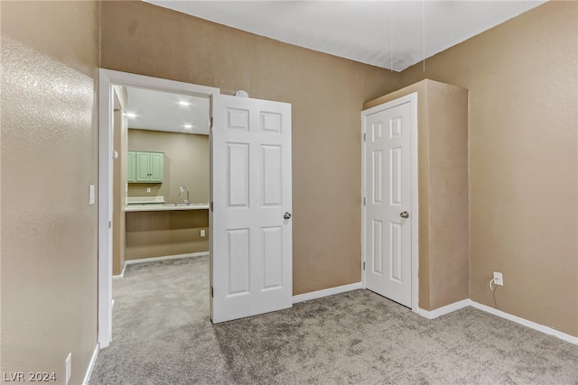 unfurnished bedroom featuring sink and light carpet