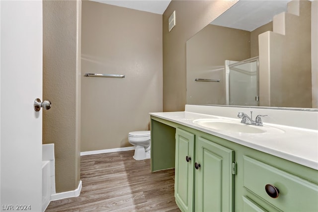 full bathroom featuring vanity, hardwood / wood-style floors, shower with separate bathtub, and toilet