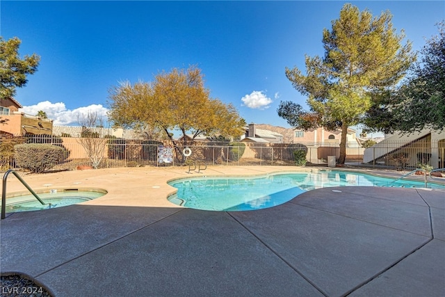 view of swimming pool with a hot tub and a patio area