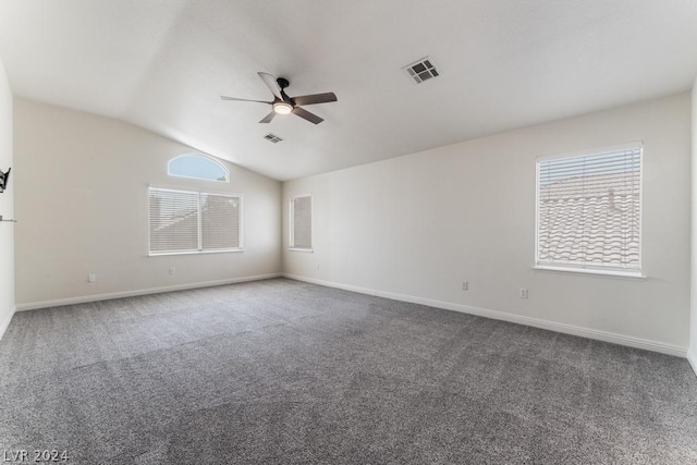 carpeted spare room featuring ceiling fan, a wealth of natural light, and lofted ceiling