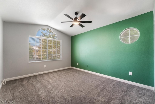 carpeted spare room featuring ceiling fan and lofted ceiling