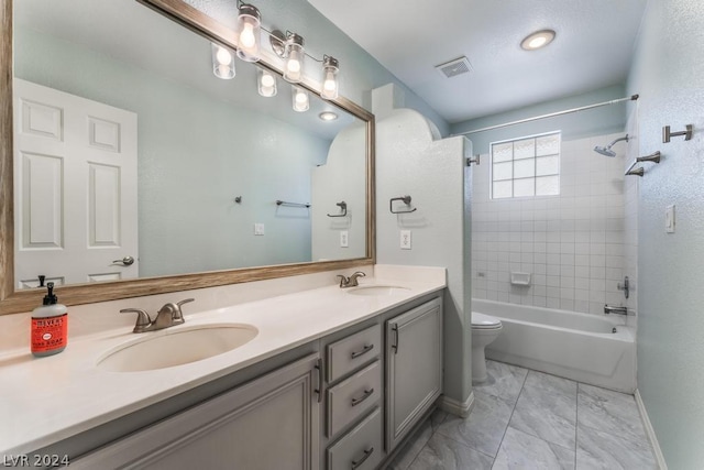 full bathroom featuring toilet, tiled shower / bath, and vanity