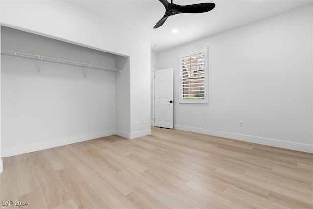 unfurnished bedroom with light wood-type flooring, ceiling fan, and a closet