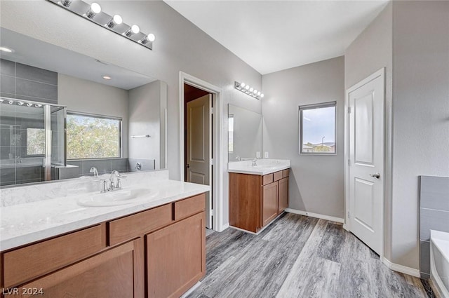 bathroom with vanity, hardwood / wood-style flooring, and plus walk in shower