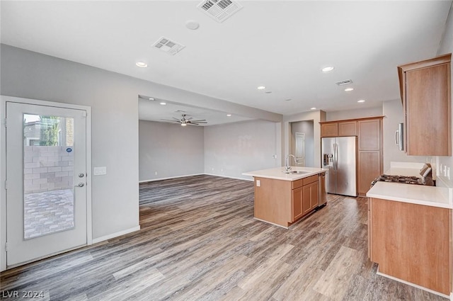 kitchen featuring sink, a center island with sink, light wood-type flooring, ceiling fan, and stainless steel appliances