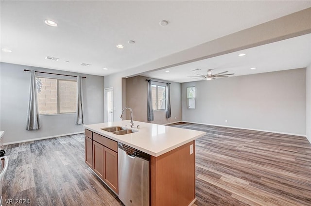 kitchen with a kitchen island with sink, dishwasher, sink, and light wood-type flooring