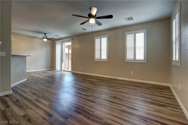 unfurnished living room with dark hardwood / wood-style flooring and ceiling fan