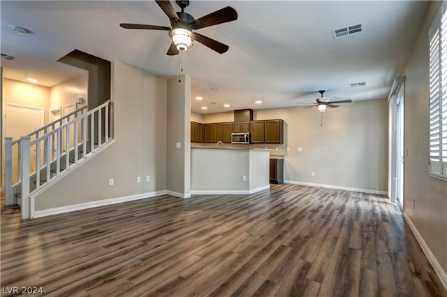 unfurnished living room with dark wood-type flooring and ceiling fan