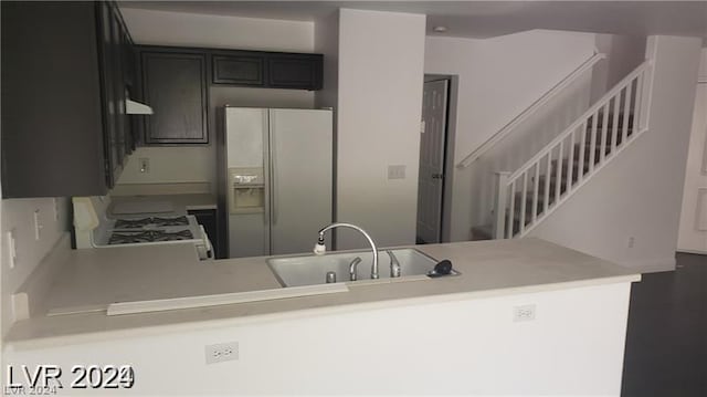 kitchen featuring sink, kitchen peninsula, and white appliances