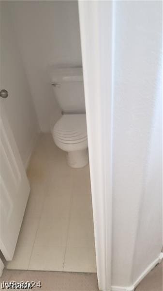 bathroom with toilet and tile patterned flooring