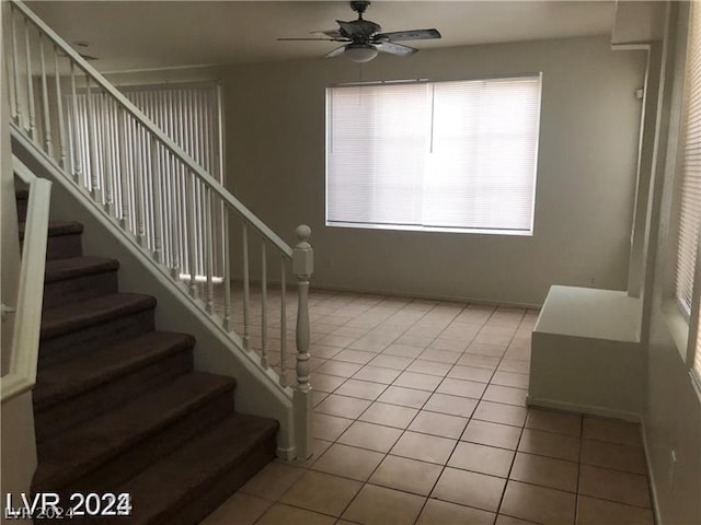 stairway featuring ceiling fan and tile patterned floors