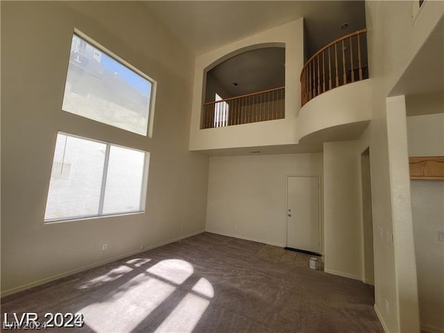 carpeted empty room with a high ceiling