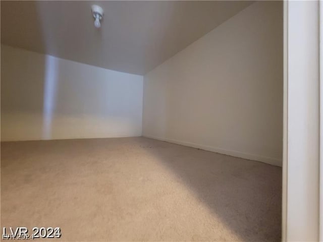 additional living space with lofted ceiling and light carpet