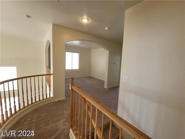 hallway featuring dark carpet