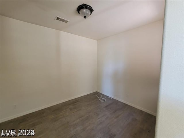 unfurnished room with dark hardwood / wood-style flooring