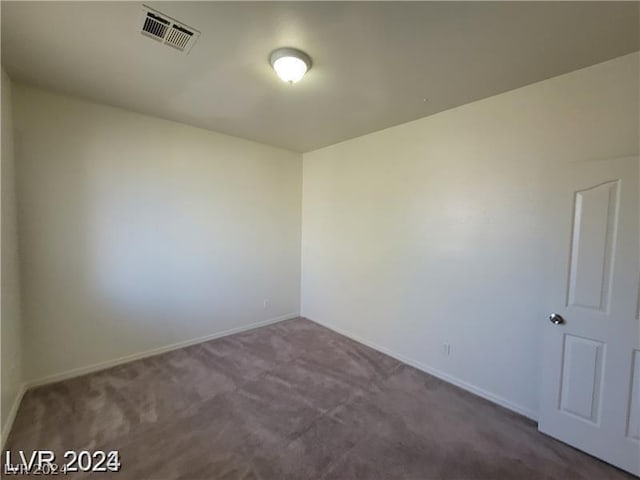 empty room featuring dark colored carpet