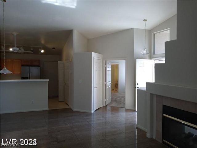 unfurnished living room featuring lofted ceiling and a tile fireplace