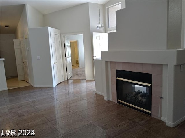 unfurnished living room with a high ceiling and a fireplace