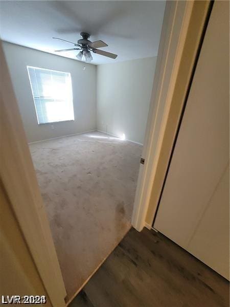 unfurnished room featuring dark wood-type flooring and ceiling fan