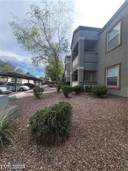 view of yard with a carport and central AC