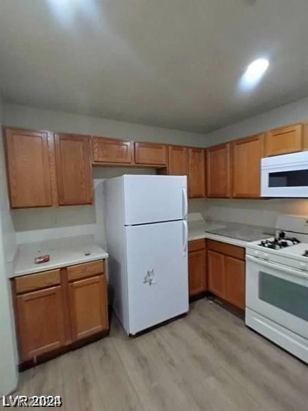 kitchen featuring white appliances and light wood-type flooring