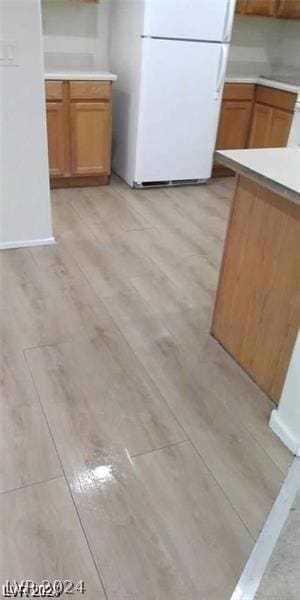 kitchen with light hardwood / wood-style flooring and white refrigerator