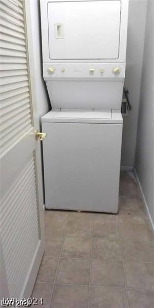 laundry area featuring tile patterned floors and stacked washer / dryer