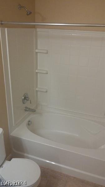 bathroom with tile patterned flooring, bathtub / shower combination, and toilet