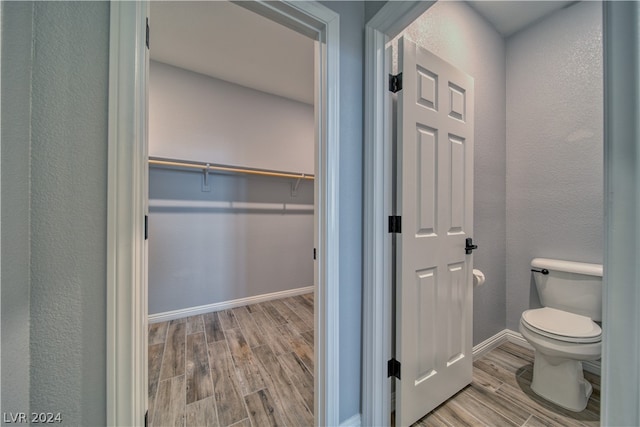 bathroom featuring hardwood / wood-style flooring and toilet