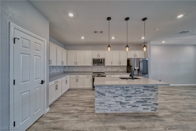 kitchen featuring stainless steel appliances, white cabinets, decorative backsplash, pendant lighting, and sink