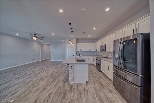 kitchen with ceiling fan, white cabinets, decorative backsplash, appliances with stainless steel finishes, and light hardwood / wood-style flooring