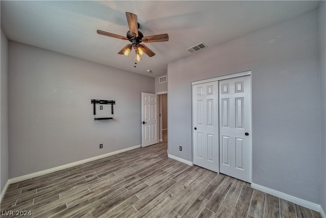 unfurnished bedroom with hardwood / wood-style flooring, a closet, and ceiling fan