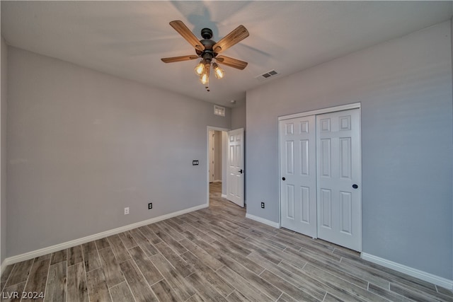 unfurnished bedroom featuring wood-type flooring, a closet, and ceiling fan