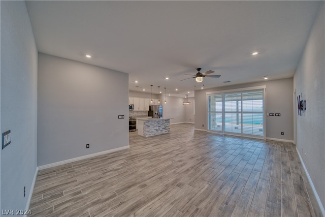 unfurnished living room with ceiling fan and light hardwood / wood-style floors