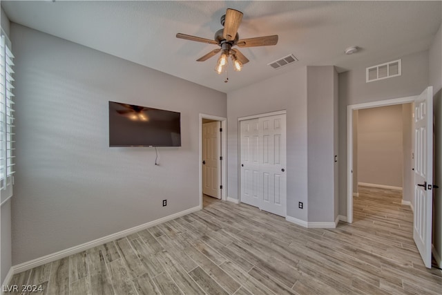 unfurnished bedroom featuring light hardwood / wood-style floors, a closet, and ceiling fan