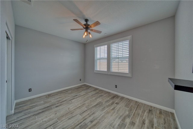 spare room with light hardwood / wood-style flooring and ceiling fan